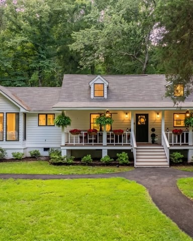 White farmhouse with wrap-around porch at dusk, Paron, AR
